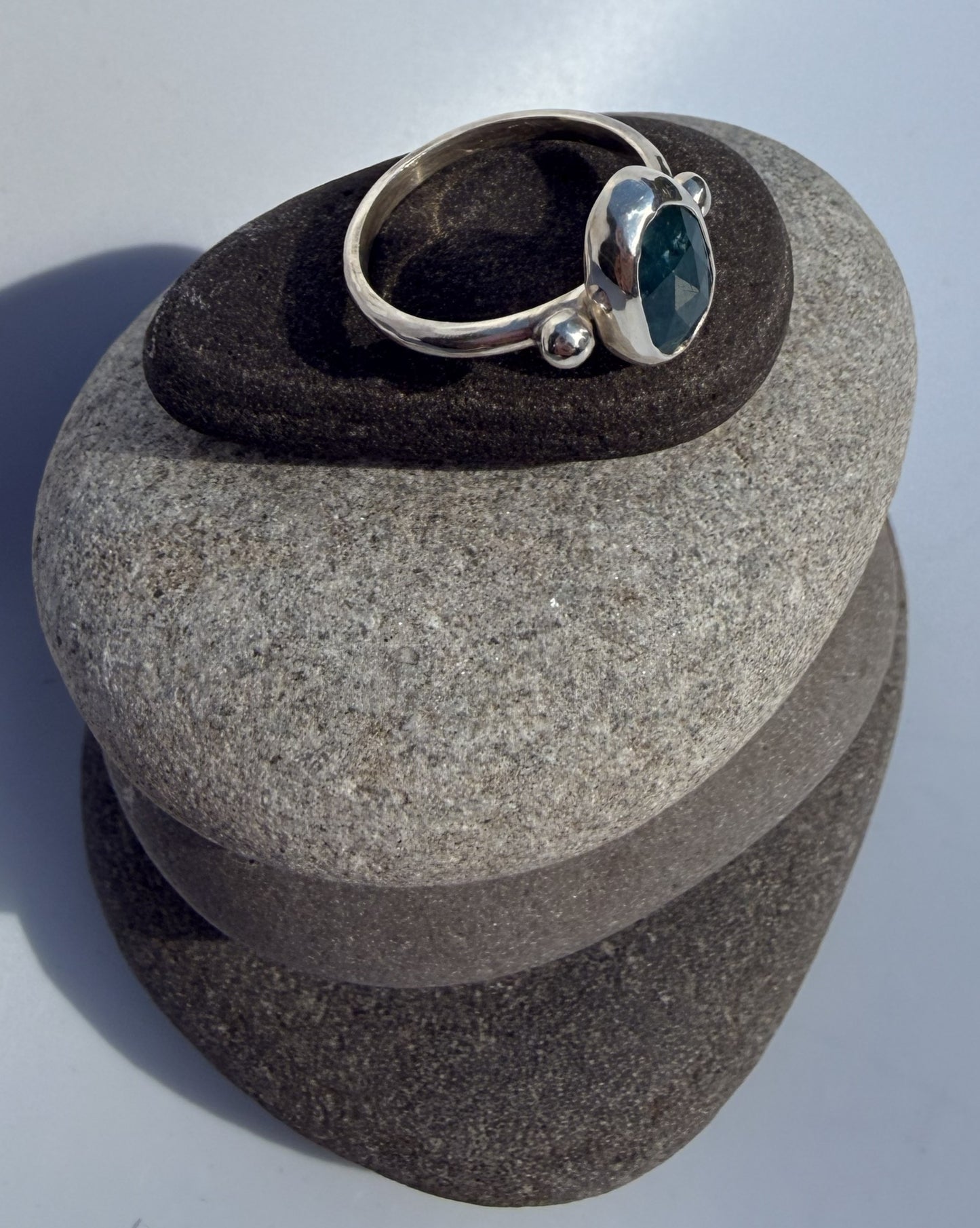 Silver ring with a blue kyanite stone on a grey stone surface