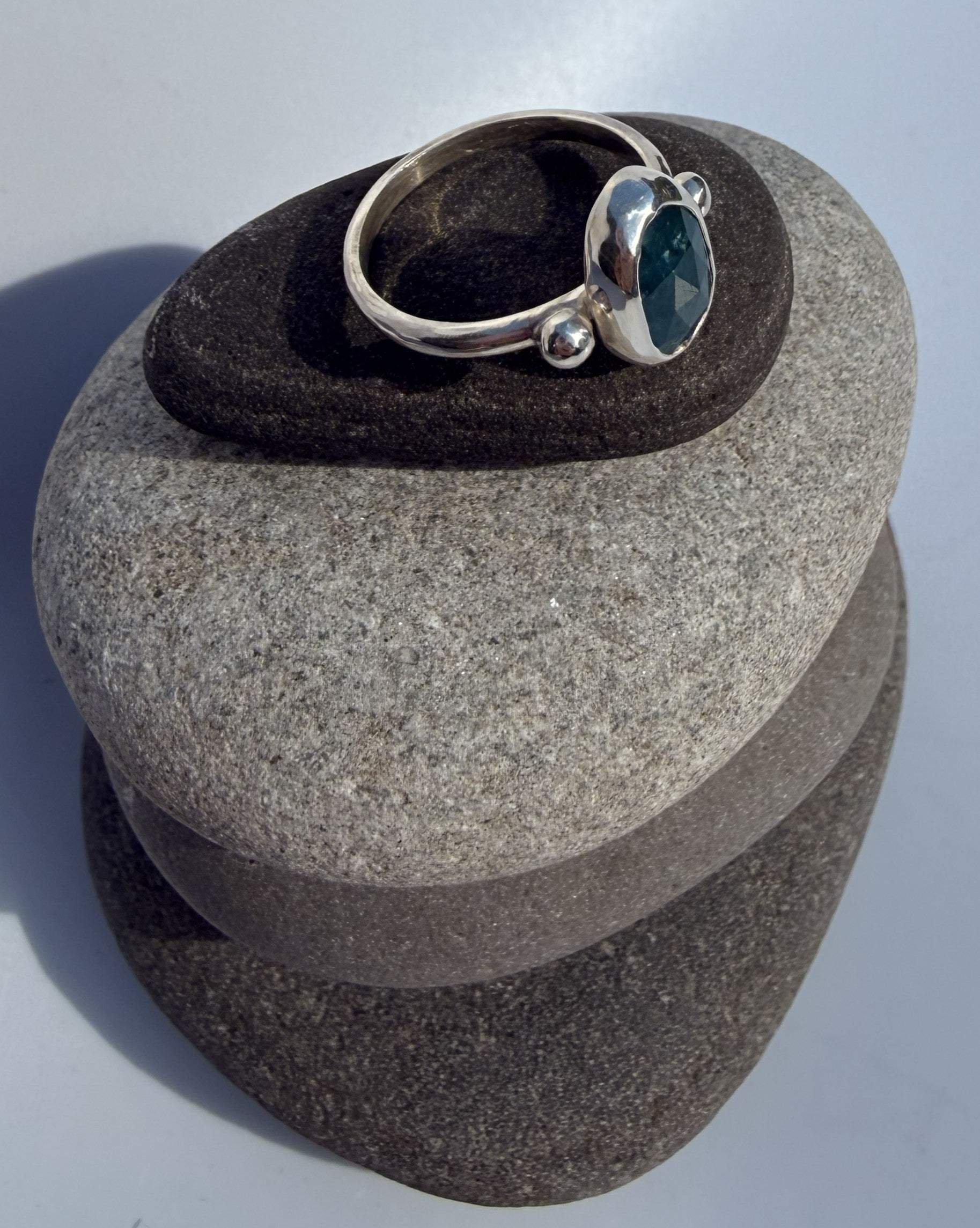 Silver ring with a blue kyanite stone on a grey stone surface