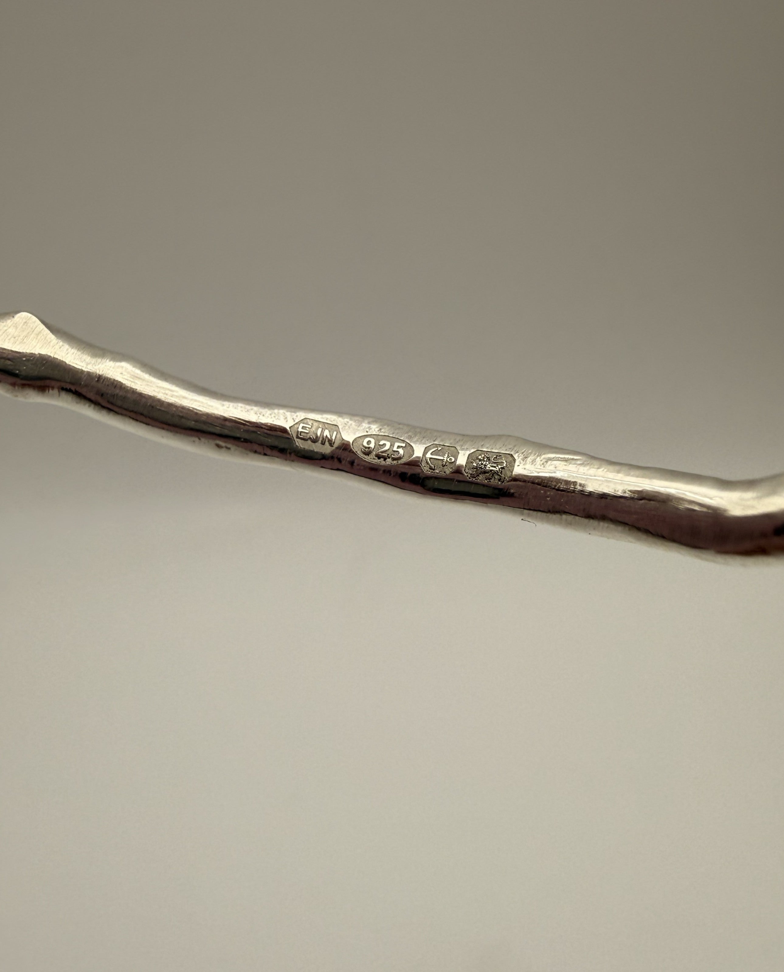 Silver bangle with UK hallmark on a grey background