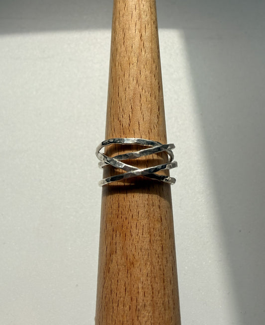 Silver ring on a wooden dowel against a white background
