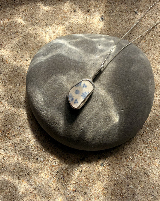 Necklace with a pendant on a stone surface