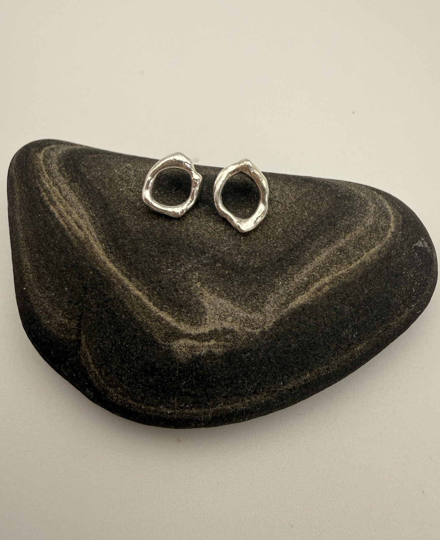 Pair of silver earrings on a black stone