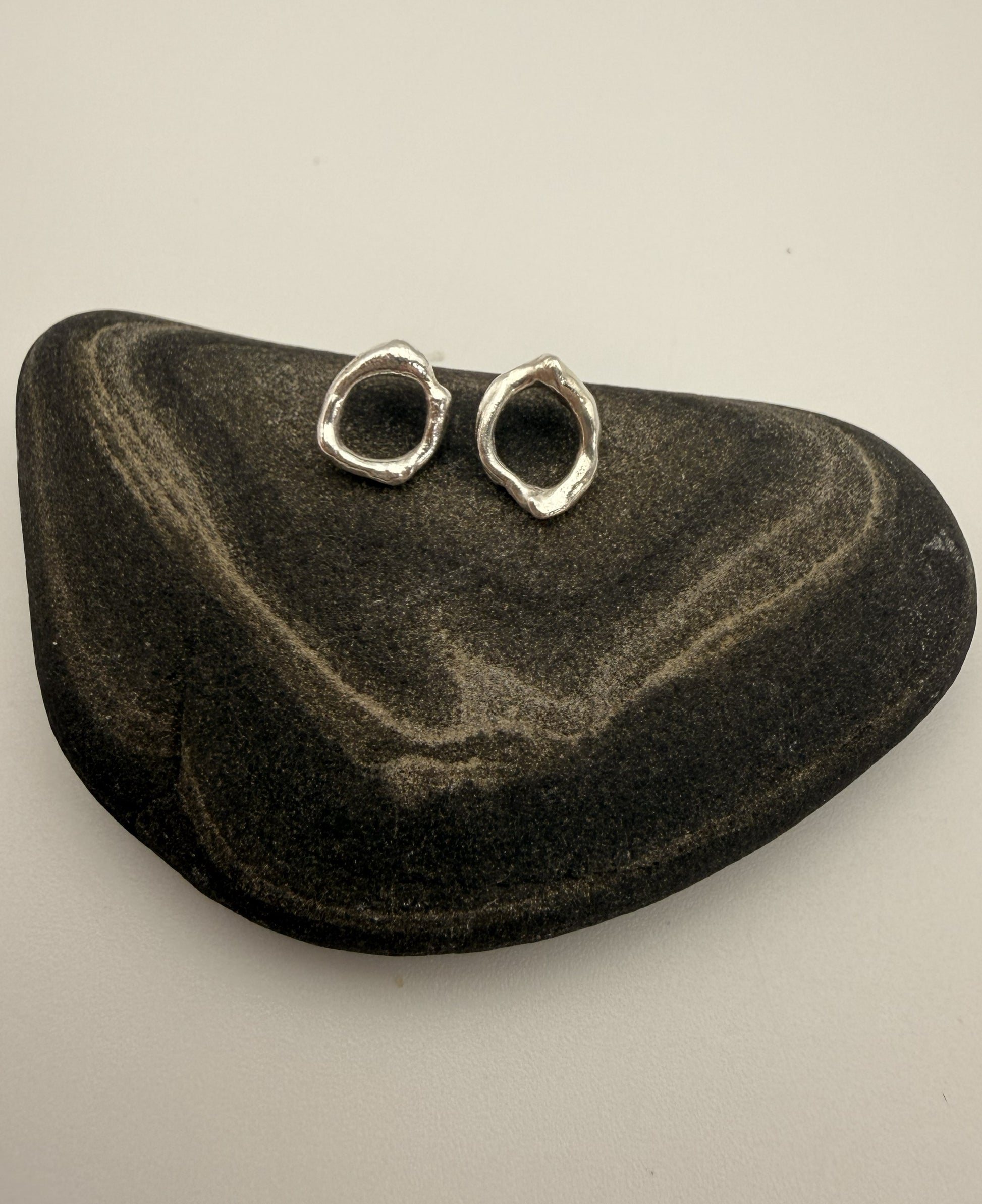 Pair of silver earrings on a black stone