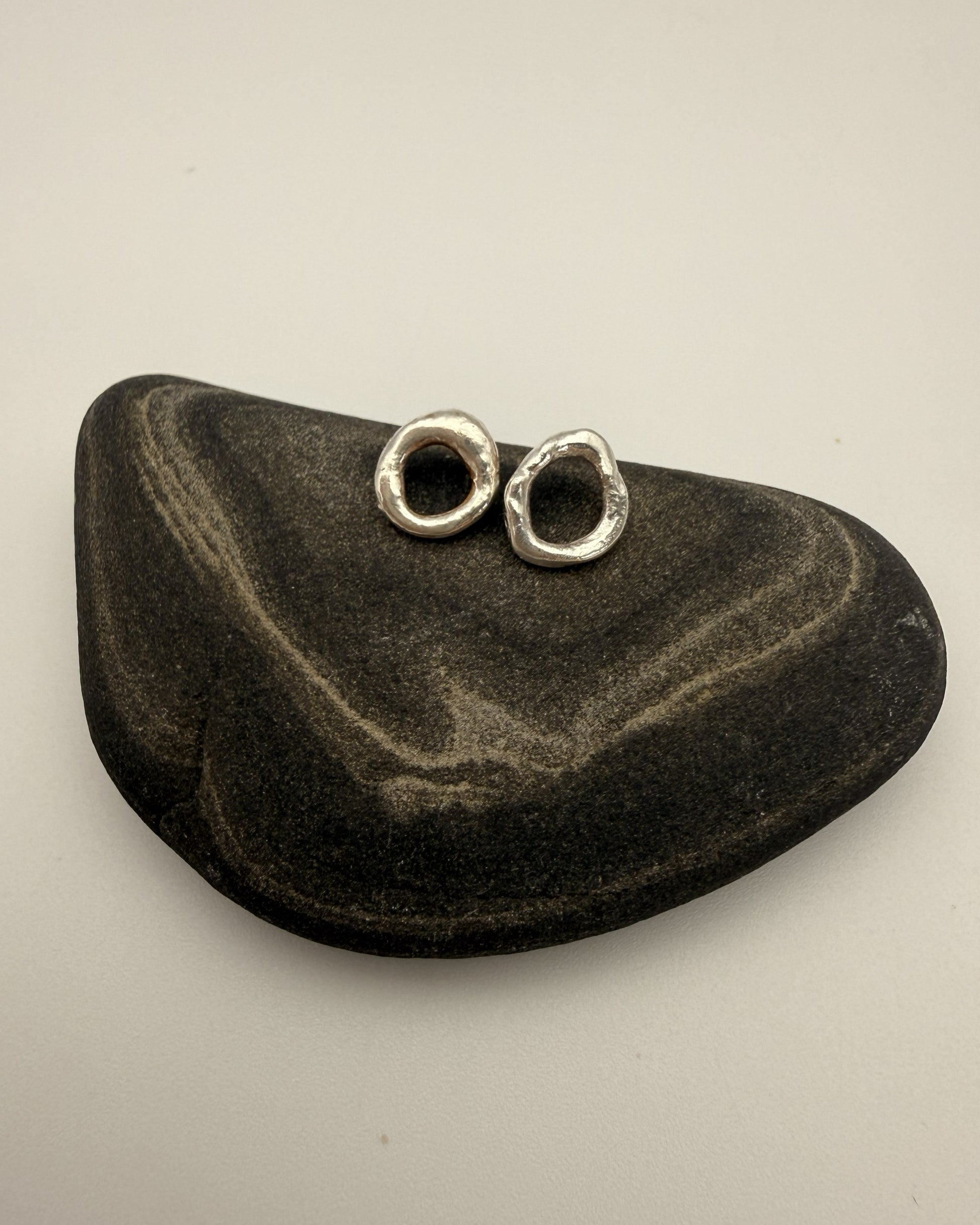 Silver earrings on a black stone