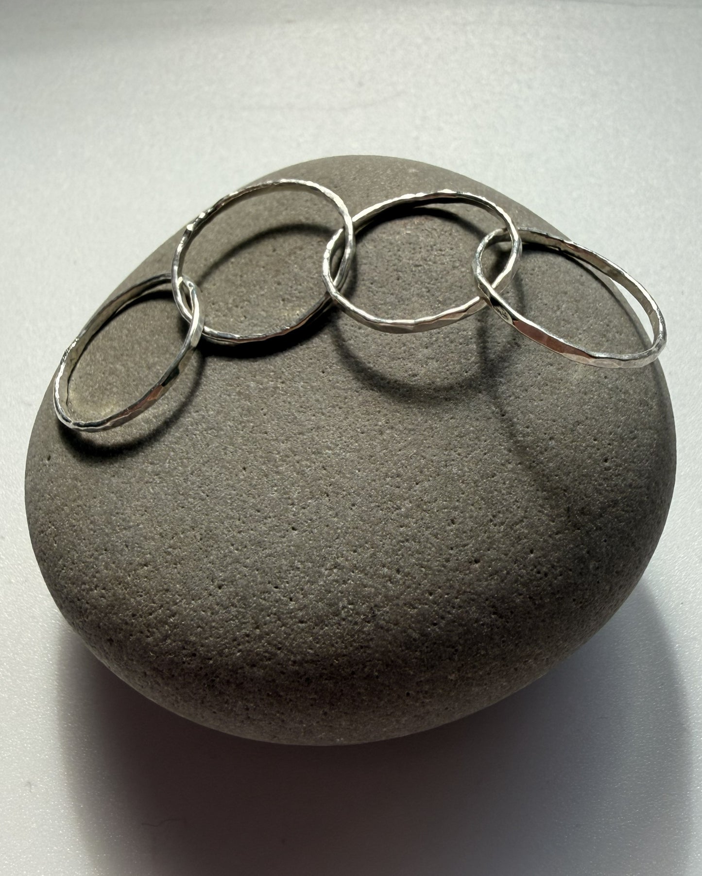  silver rings on a gray stone surface