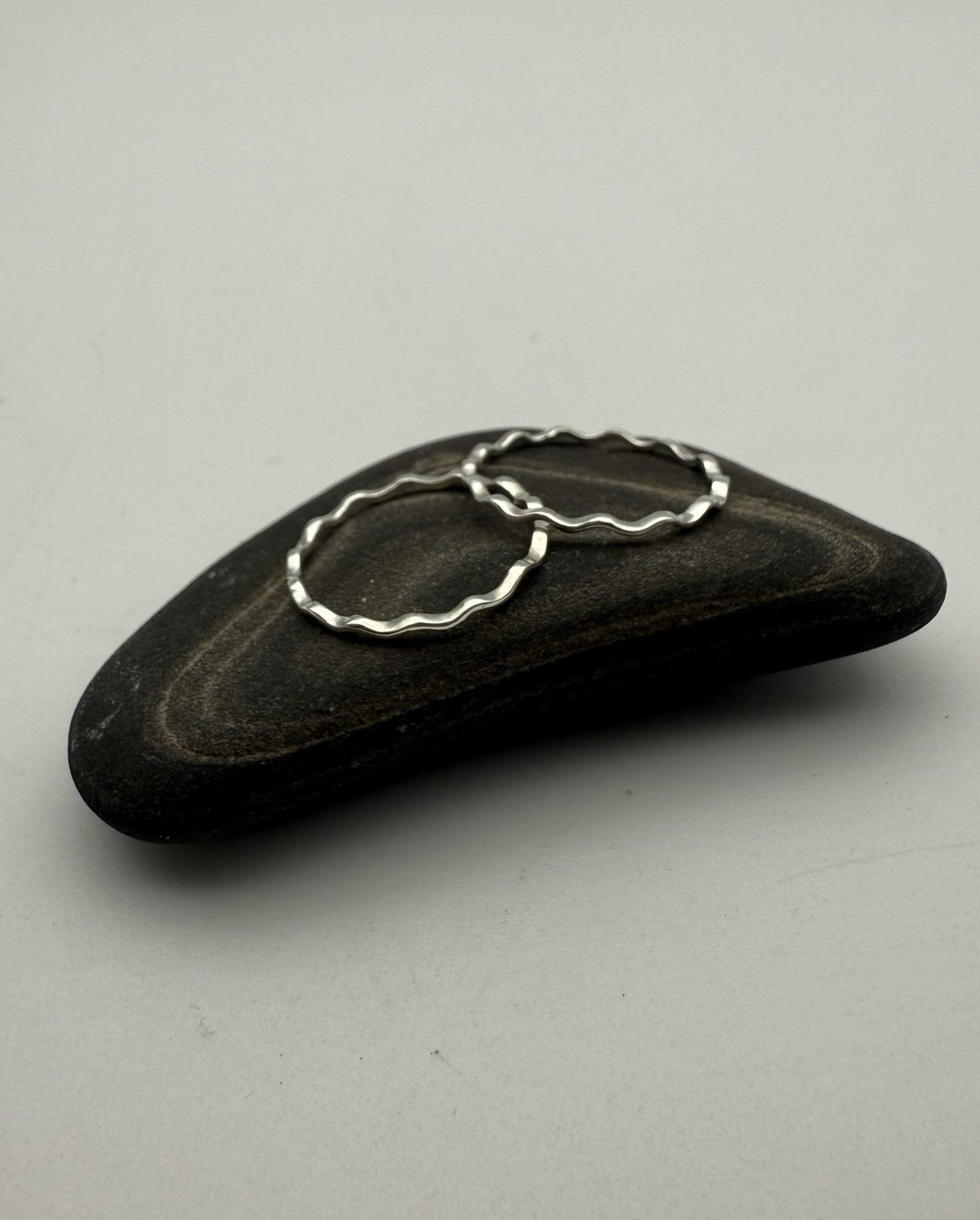 Black stone with a silver ring on a gray background