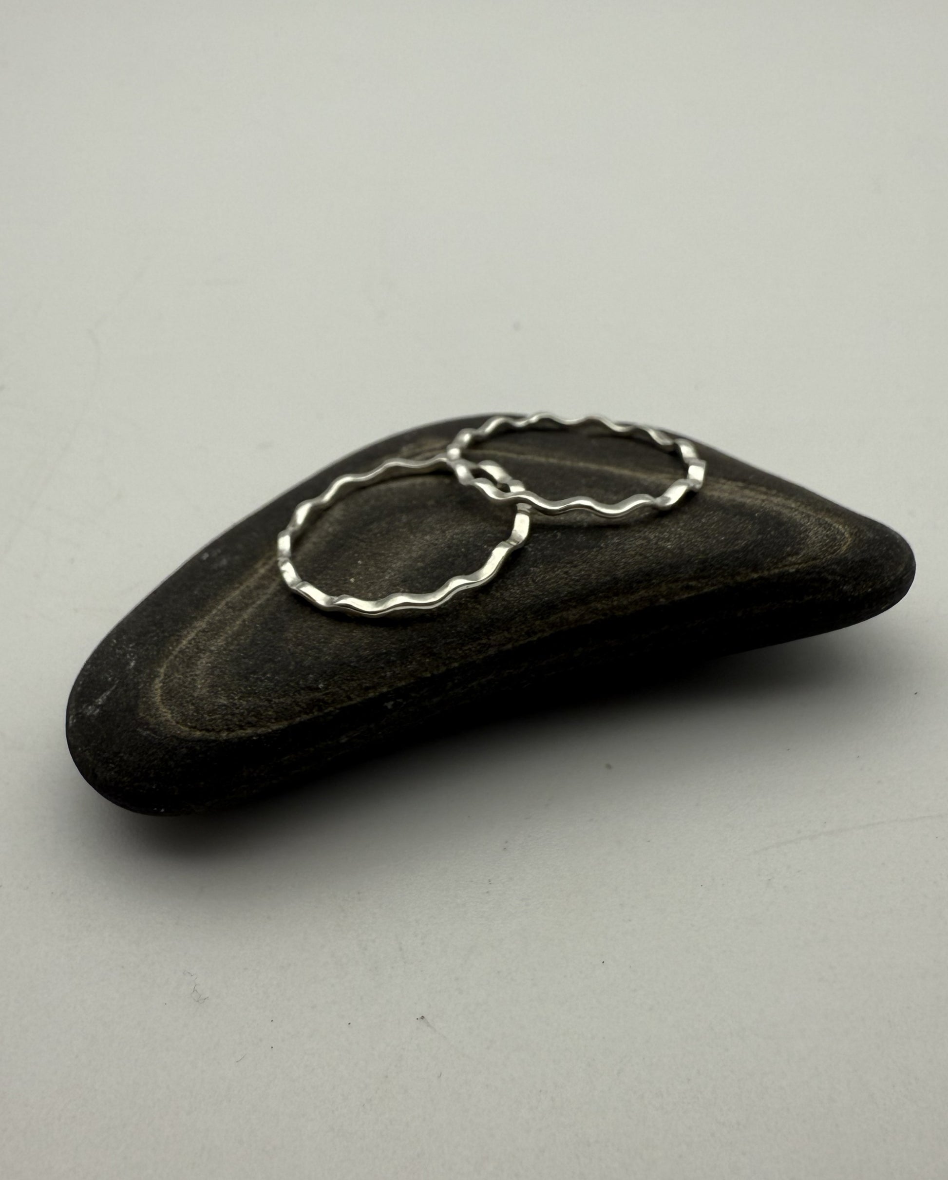 Black stone with a silver ring on a gray background