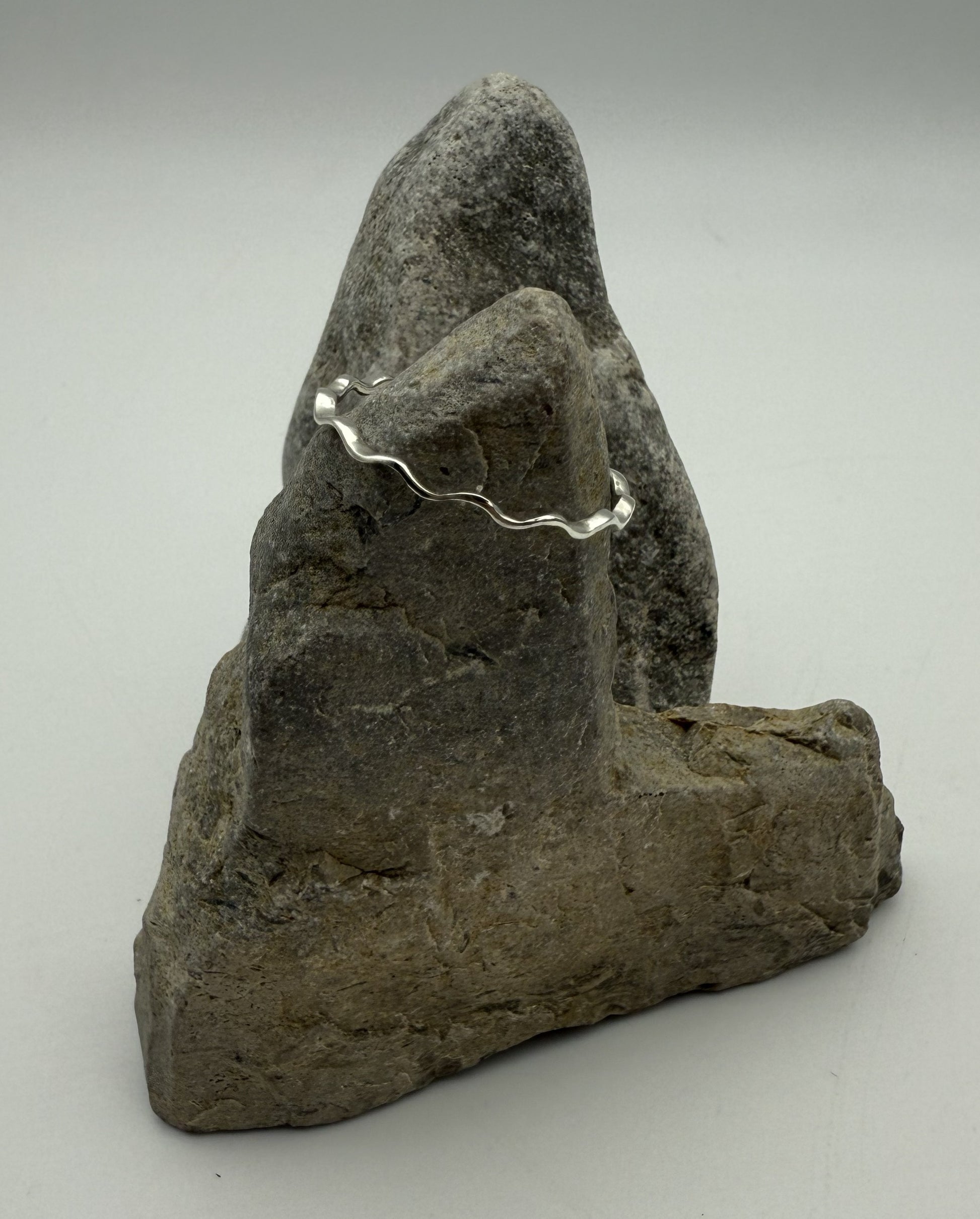 Silver ring on a gray stone surface