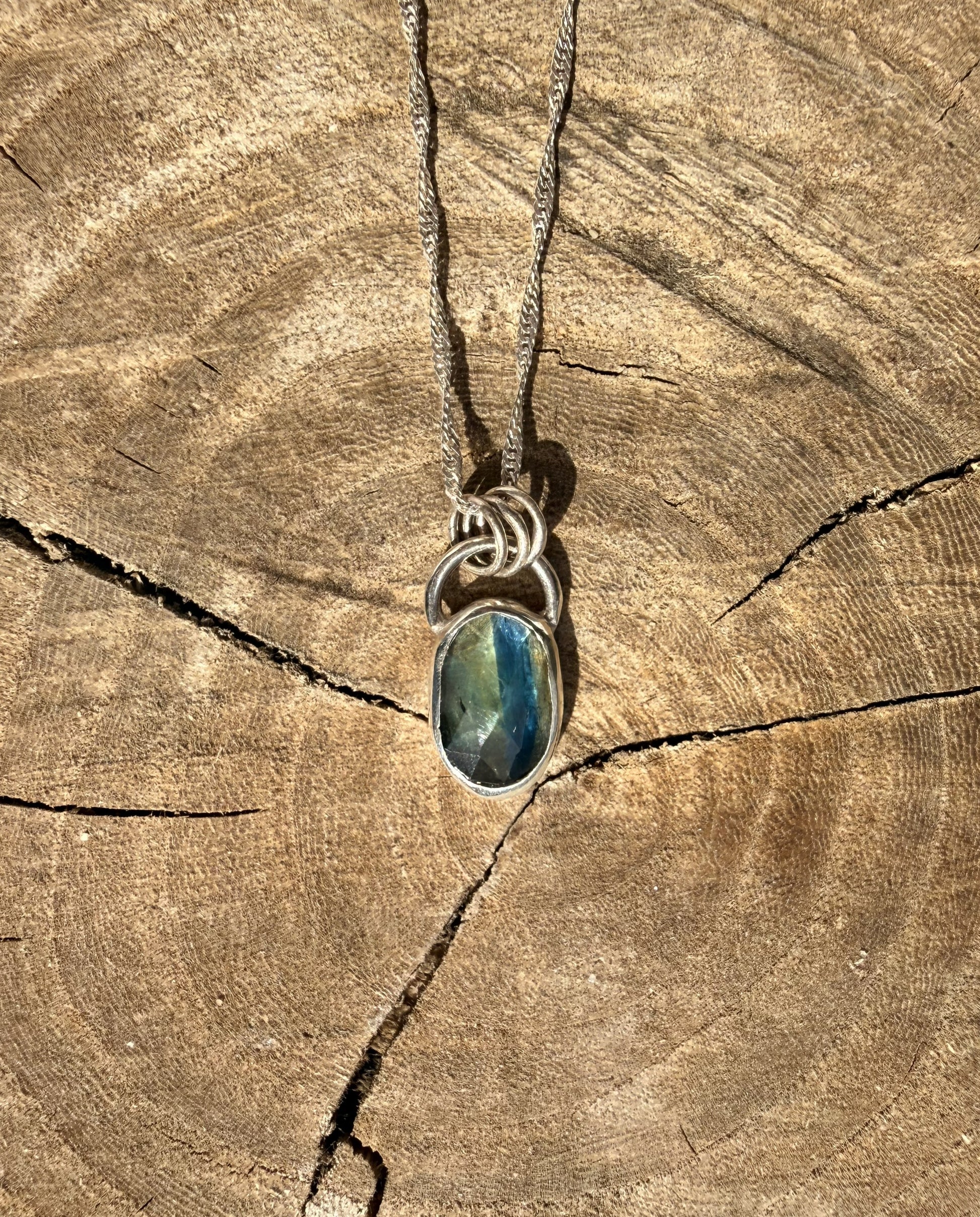 Necklace with a blue kyanite pendant on a wooden surface
