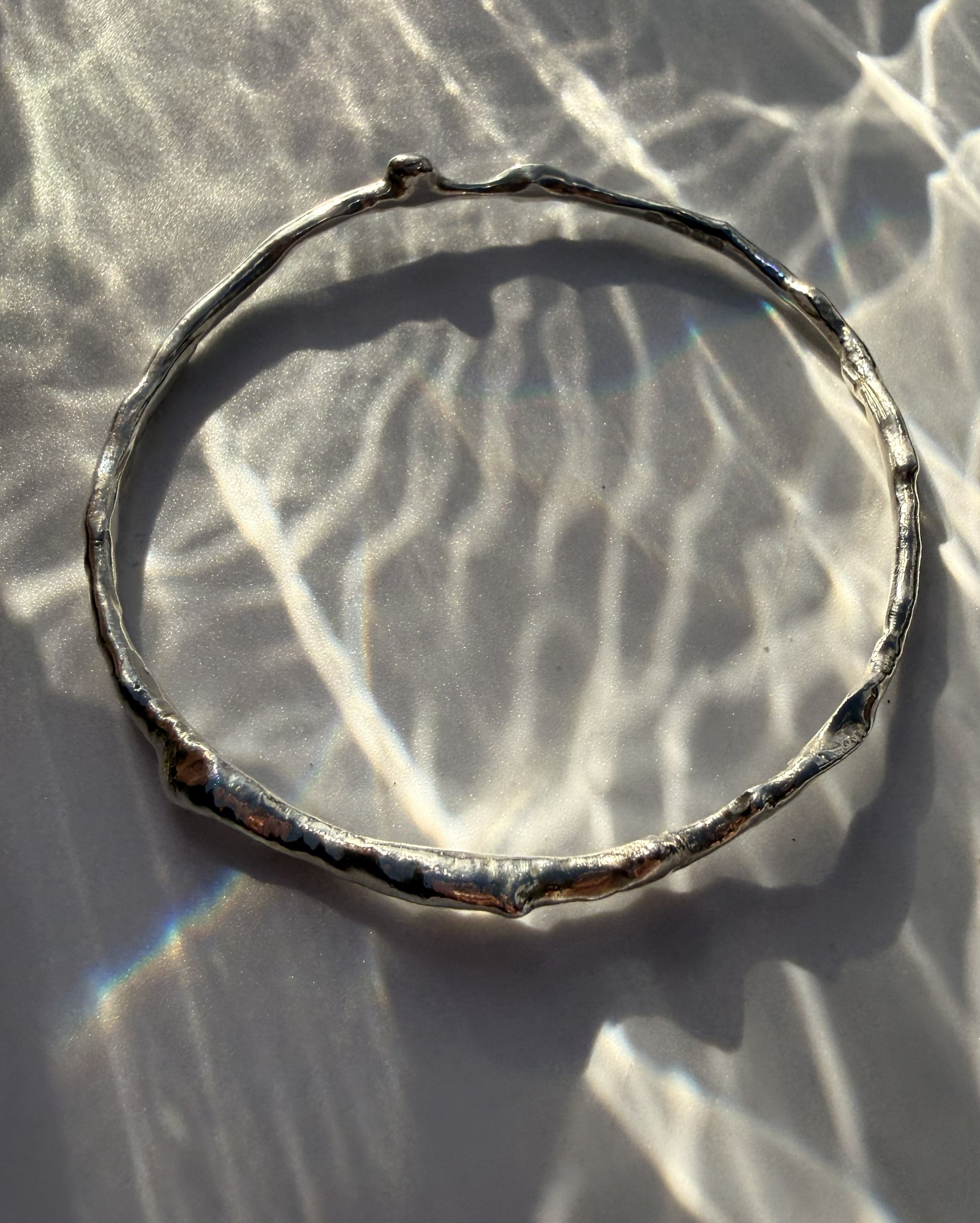 Silver bracelet on a textured white surface