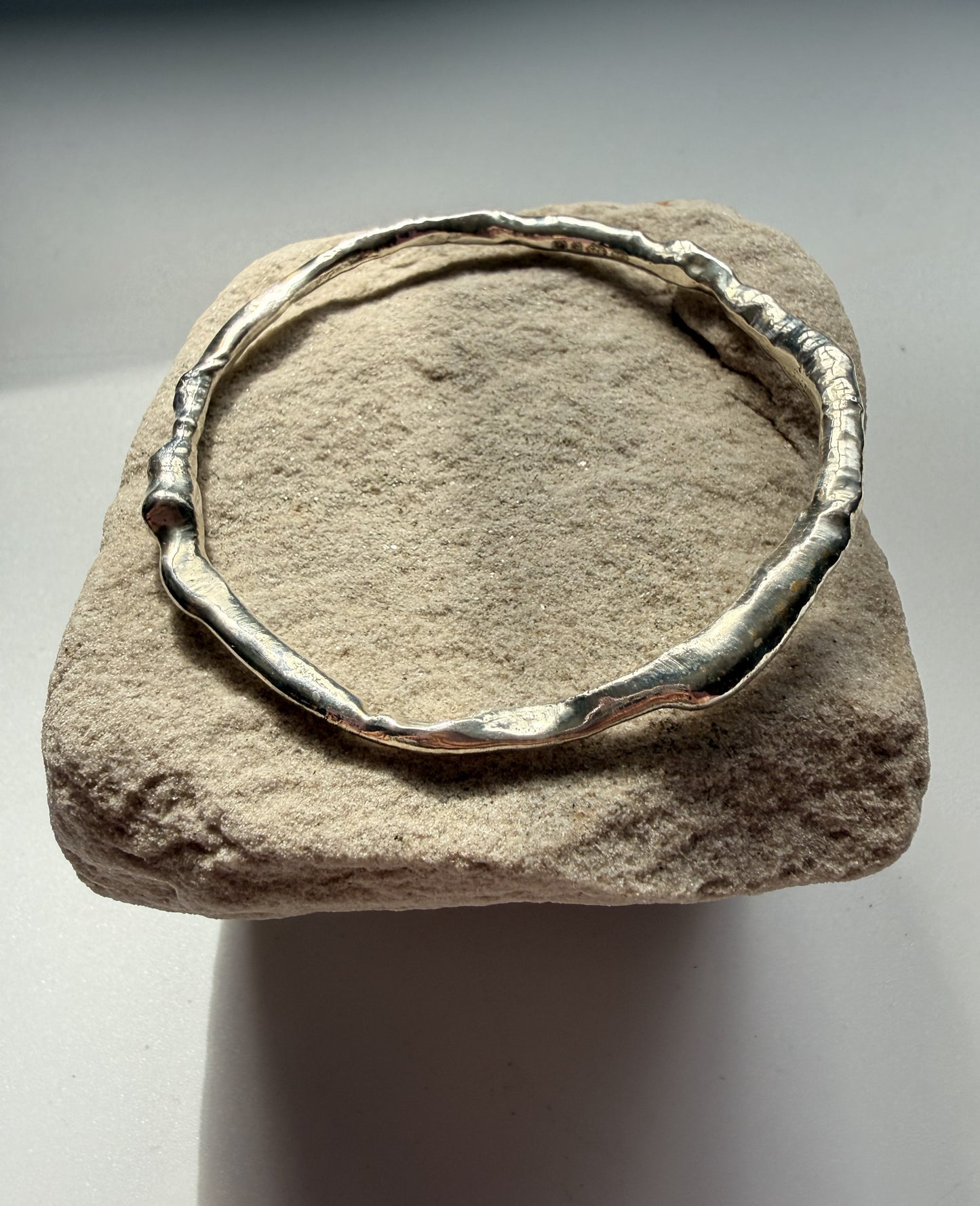 Silver bracelet on a textured stone surface