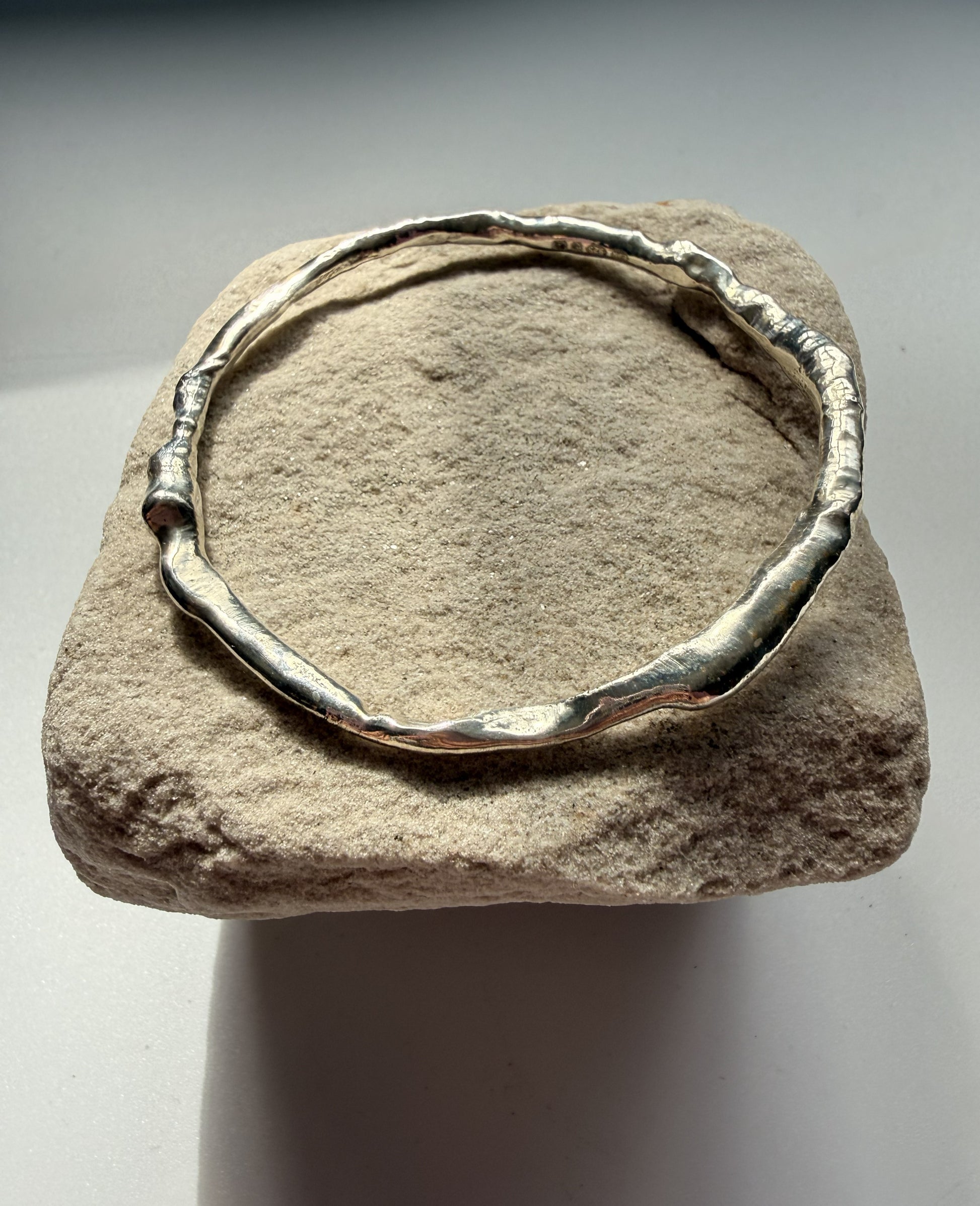Silver bracelet on a textured stone surface