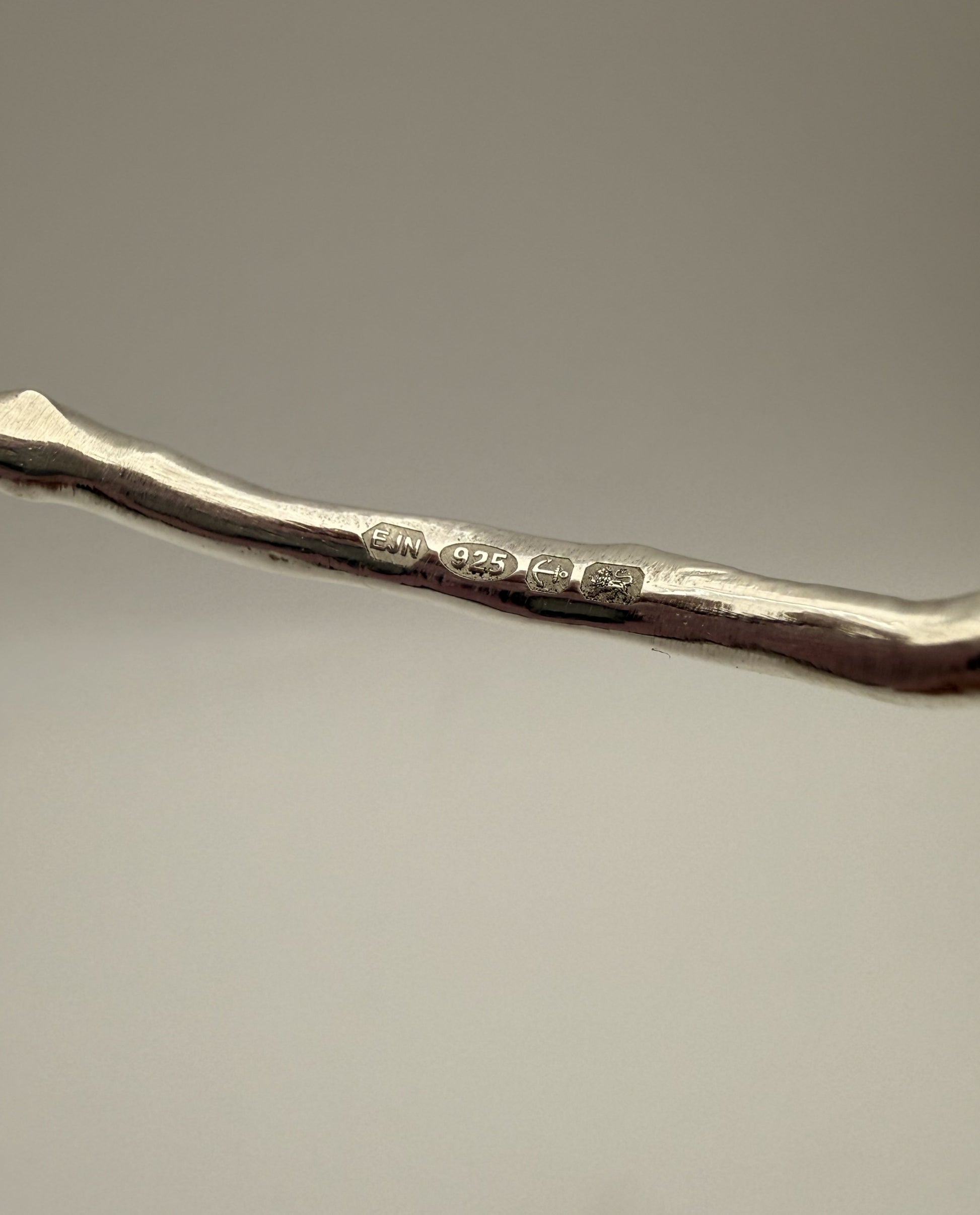 Silver bangle with UK hallmark on a grey background