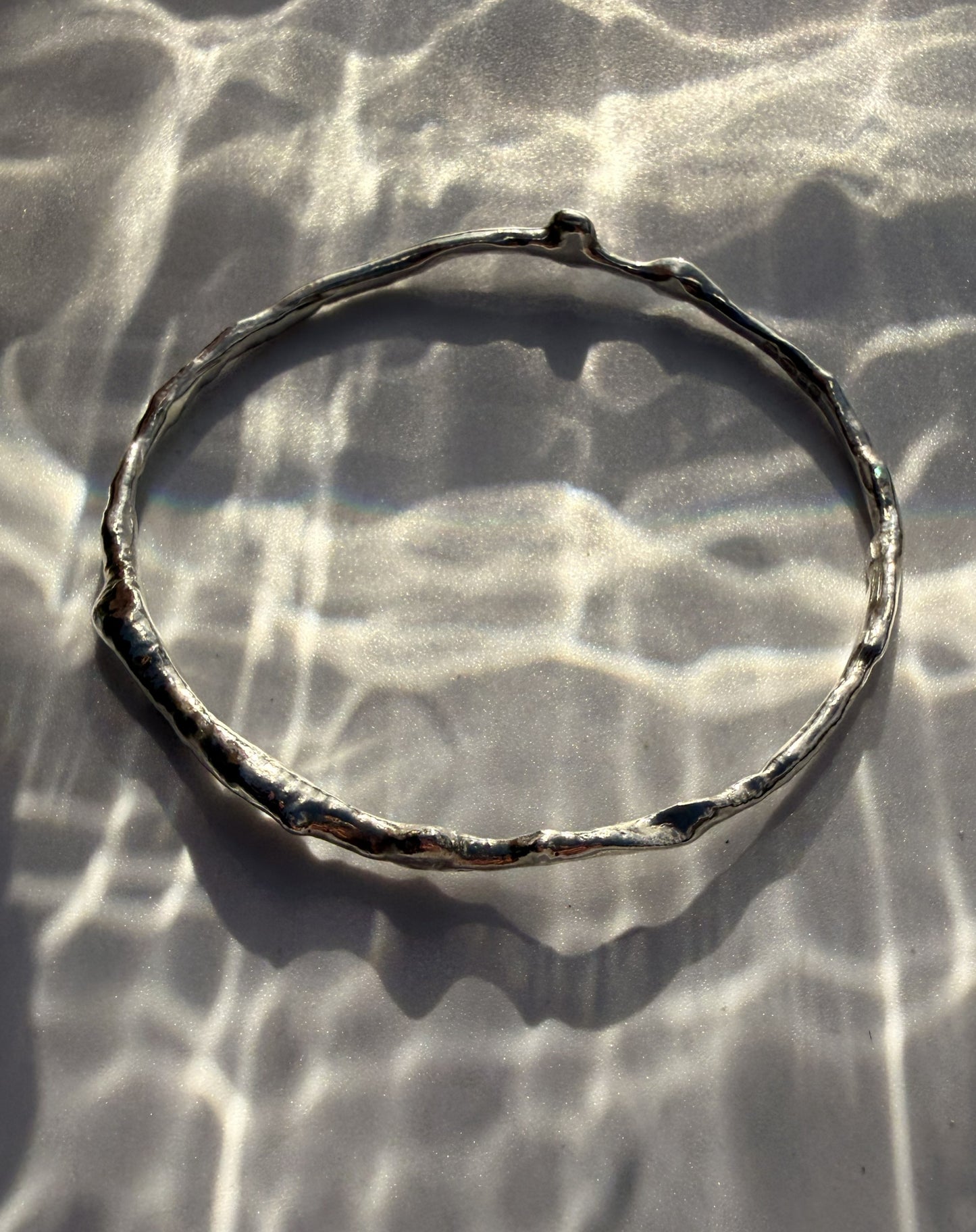 Silver bracelet on a textured surface