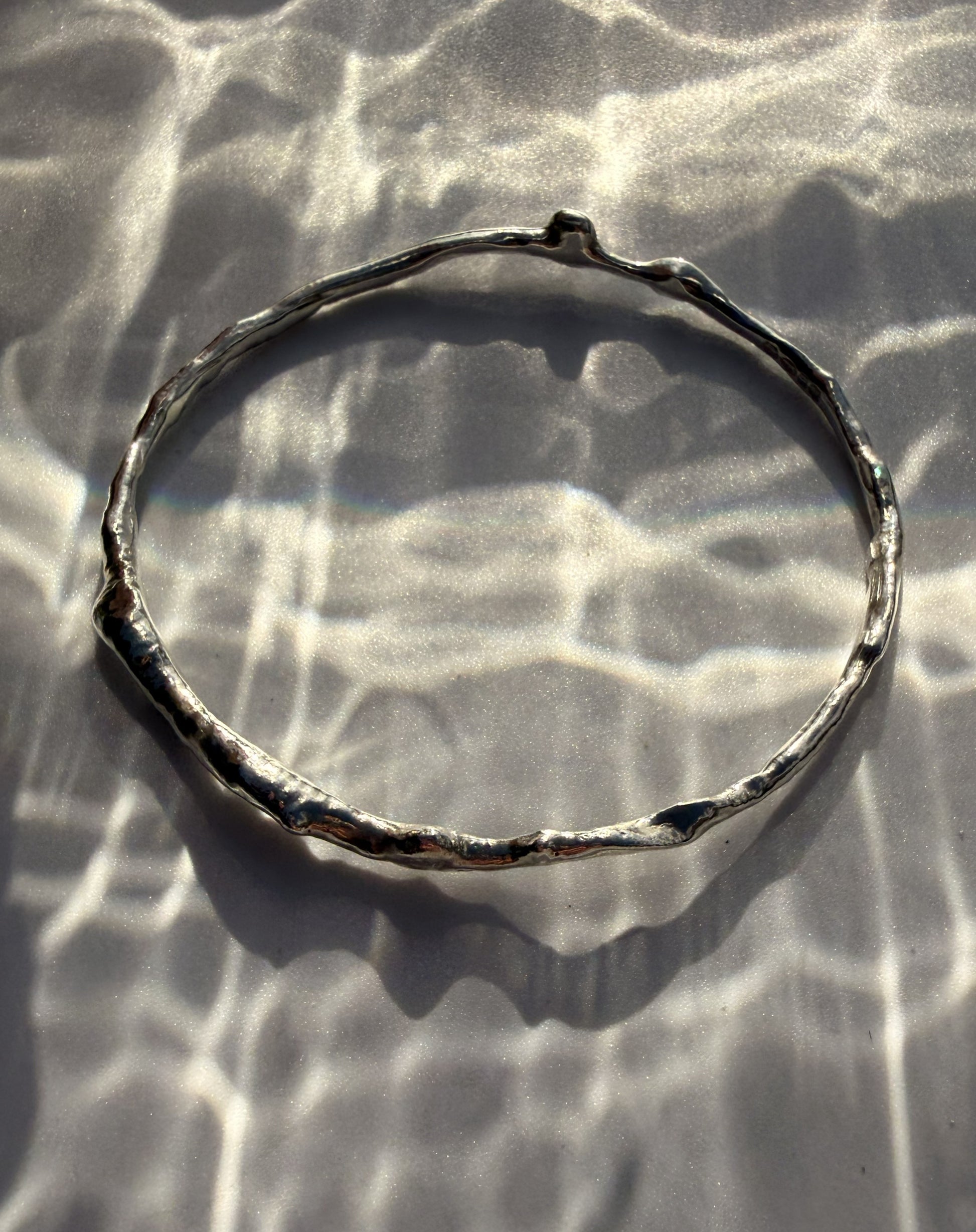 Silver bracelet on a textured surface