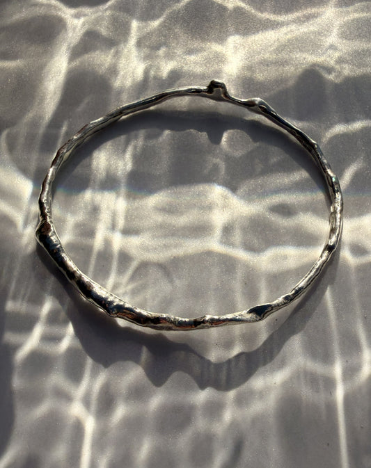 Silver bracelet on a textured surface